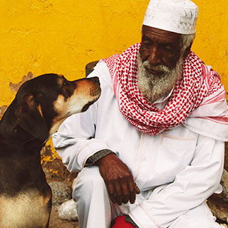 Man and dog sitting on the street